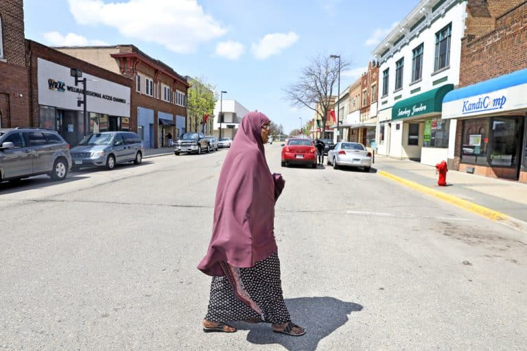 Faiza Dalmar Awil crossing the street between her restaurant, Somali Star, and her shop in Willmar, Minn. Jenn Ackerman for The New York Times