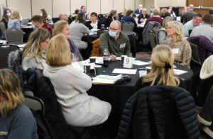 Professionals discuss workforce issues around a table during the Workforce Solutions Summit in January 2022