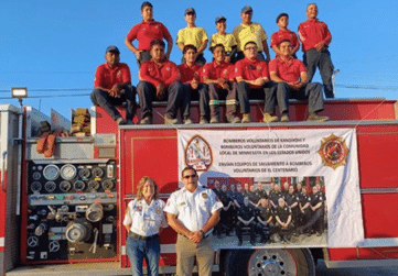 Mexican firefighters pose around a fire truck