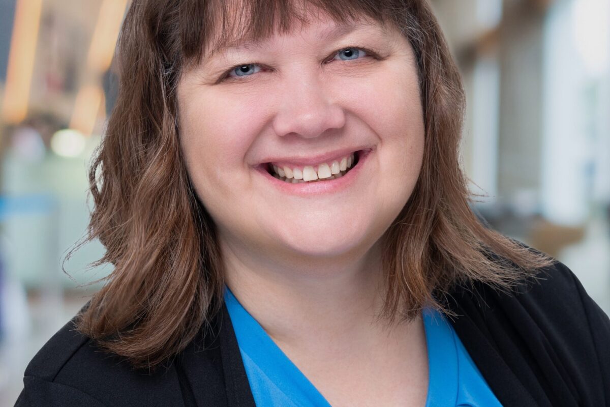 head shot of Michelle, a white woman with brown hair, in a blue shirt and black blazer